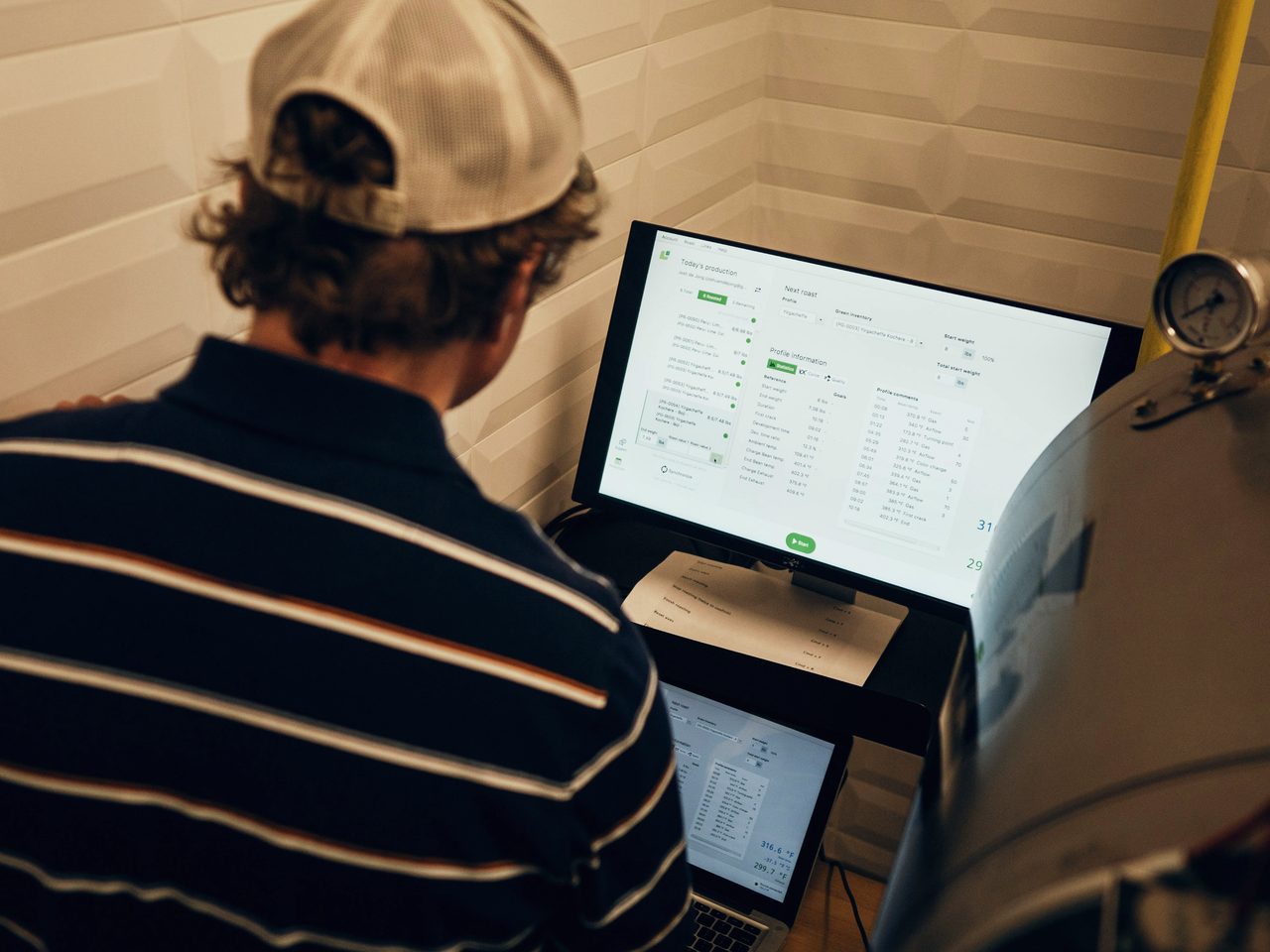 Persona revisando indicadores en una pantalla instalada en planta.