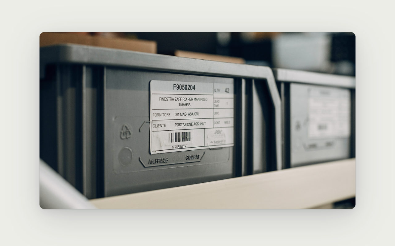 Tarjeta kanban con código de barras en un contenedor lleno.
